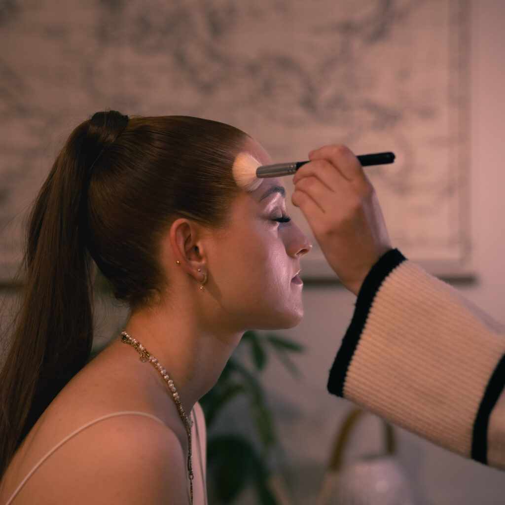 Préparation maquillage pour teint naturel avec pinceau pour une jeune femme brune